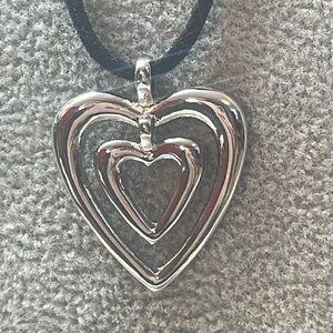 Double heart pendant in Silvertone 1.25”x 1/4“ x 1“, black cording
NWT